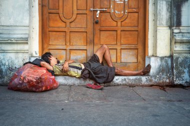 01 / 21 / 2020 Yangon, Myanmar. Yangon Caddesi 'ndeki basamaklarda evsiz Burmalı demirci