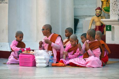 01 / 212020 Myanmar, Yangon, Shwedagon Altın Pagoda yakınlarında dua eden bir grup genç keşiş. Shwedagon Pagoda - Myanmar 'ın en kutsal Budist tapınağı