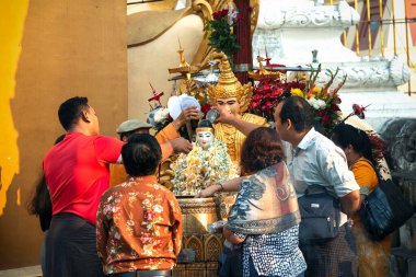 01 / 21 / 2020 Myanmar, Yangon, Altın Pagoda The Shwedagon ve pek çok ibadet eden Buda heykelinin yanında dua ediyor. Shwedagon Pagoda, Myanmar 'daki en kutsal Budist tapınağıdır.