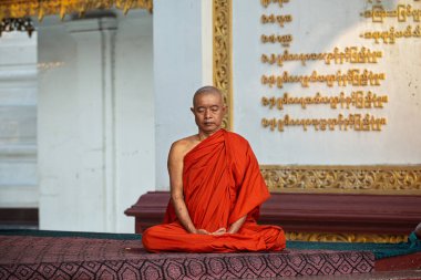 01 / 21 / 2020 Myanmar, Yangon, Altın Pagoda Shwedagon yakınlarında dua eden yalnız bir keşiş. Shwedagon Pagoda, Myanmar 'daki en kutsal Budist tapınağıdır.