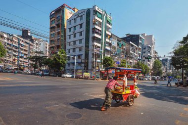 21 / 02 / 2020 Yangon Myanmar (Burma). Adam caddenin aşağısındaki yemek tezgahını itiyor. Geleneksel olarak Birmanyalılar sokaklarda oturup yemek yerler.