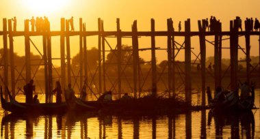 Mandalay, Myanmar (Burma), Sunset of Unknown people U bein Bridge in Amarapura across Ayeyarwady Riverin. U-bein Köprüsü dünyadaki en eski ve en uzun tahta köprüdür.