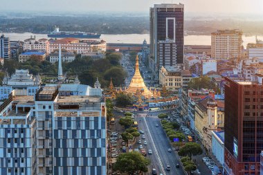 01 / 22 / 2020 Yangon, Myanmar (Burma), Aerial shot, Shwedagon Pagoda ile Yangon 'un aşağısındaki İHA' dan görüş ve günbatımı renklerinde sokak trafiği. Yangon - Burma 'nın antik başkenti