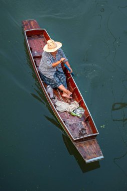 Tayland, Ratchaburi, Ratchaburi 'deki ünlü Damnoen Saduak yüzer marketi. Yerel kadın meyve, yiyecek ve hediyelik eşya ticareti yapıyor. Dünyanın dört bir yanından gelen turistler arasında çok popüler bir yer.