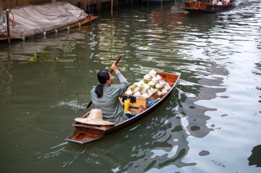 02.02.2020 Tayland, Ratchaburi, Ratchaburi, Ratchaburi 'deki ünlü Damnoen Saduak yüzen pazarı. Yerel kadın meyve, yiyecek ve hediyelik eşya ticareti yapıyor. Dünyanın dört bir yanından gelen turistler arasında çok popüler bir yer.
