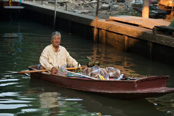 02.02.2020 Tayland, Ratchaburi, Ratchaburi, Ratchaburi 'deki ünlü Damnoen Saduak yüzen pazarı. Buralı bir adam teknesiyle pazar kanallarından geçiyor. Dünyanın dört bir yanından gelen turistler arasında çok popüler bir yer.