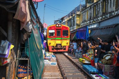 02.02.2020 Tayland, Samut Songkhrami, Mae Klong demiryolu pazarı Siang Tai olarak da bilinir. Turistler tren rayları boyunca yürüyüp geçen trenin fotoğraflarını ve selfielerini çekiyorlar. Dünyanın her yerinden gelen turistler arasında popüler bir yer.