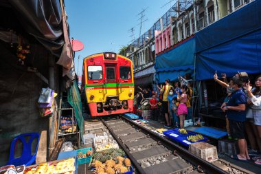 02.02.2020 Tayland, Samut Songkhrami, Mae Klong demiryolu pazarı Siang Tai olarak da bilinir. Turistler tren rayları boyunca yürüyüp geçen trenin fotoğraflarını ve selfielerini çekiyorlar. Dünyanın her yerinden gelen turistler arasında popüler bir yer.