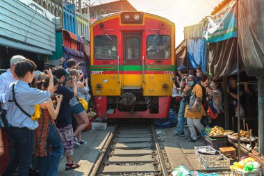 02.02.2020 Tayland, Samut Songkhrami, Mae Klong demiryolu pazarı Siang Tai olarak da bilinir. Turistler tren rayları boyunca yürür ve yaklaşan trenin fotoğraflarını ve selfielerini çekerler. Dünyanın her yerinden gelen turistler arasında popüler bir yer.