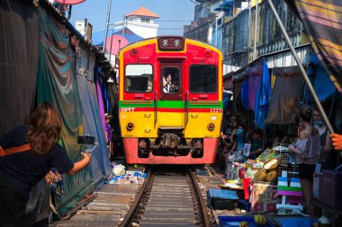 02.02.2020 Tayland, Samut Songkhrami, Mae Klong demiryolu pazarı Siang Tai olarak da bilinir. Turistler tren rayları boyunca yürür ve yaklaşan trenin fotoğraflarını ve selfielerini çekerler. Dünyanın her yerinden gelen turistler arasında popüler bir yer.