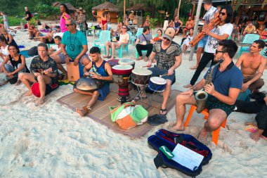 02.16.2020 Tayland, Ko Pha Ngan. İnsanlar, Haad Rin Sahili 'nde popüler Dolunay Partisi festivalinde bir çember oluşturup dans ediyor ve enstrüman çalıyorlar.