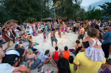 02.16.2020 Tayland, Ko Pha Ngan. İnsanlar, Haad Rin Sahili 'nde popüler Dolunay Partisi festivalinde bir çember oluşturup dans ediyor ve enstrüman çalıyorlar.