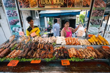 01 / 10 / 2020 Tayland. Lezzetli bir sokak yemeği satıcısı Tayland restoranında bbq tavuk ve et hazırlar ve satar. Barbekü karidesleri. Tayland, Ko Pha Ngan. sokak yemekleri konsepti