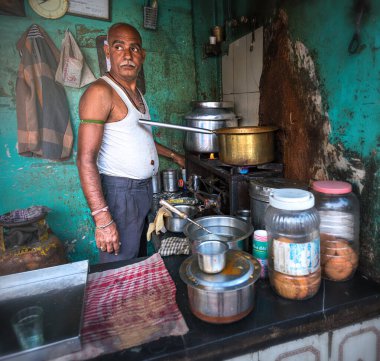 08 / 01 / 2020 Hindistan, Mumbai, Mumbai 'nin varoşlarındaki Dhobi Ghat' ta aromatik masala çayı yapan bir adam. Hijyen eksikliği ve sokak yemeklerinin hijyenik normları