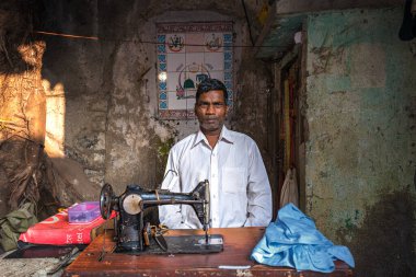 08 / 01 / 2020 Hindistan, Mumbai, Mumbai, Dhobi Ghat 'ta dikiş makinesiyle çalışan bir adam. Modern bir şehrin sokaklarında el emeği talep ediliyor.