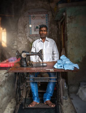 08 / 01 / 2020 Hindistan, Mumbai, Mumbai, Dhobi Ghat 'ta dikiş makinesiyle çalışan bir adam. Modern bir şehrin sokaklarında el emeği talep ediliyor.