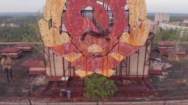 Pripyat, Ukrayna, hayalet şehrin çatısındaki SSCB işareti üzerinde hava manzarası. Sovyet arması Pripyat 'ta beton bir binada, insansız hava aracı 4k... mp4' ten görünüyor.