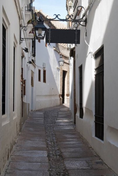 Street decorated with white houses and sign gets souk. It is Situated in a village in Spain Called Cordoba