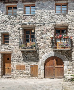 Çiçeklerle süslenmiş antik bir evin cephesi