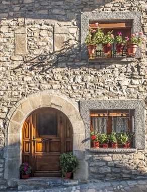 Çiçeklerle süslenmiş antik bir evin cephesi