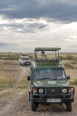 AMBOSELI, Kenya - Mayıs 2014. Kenya Ulusal Parkı 'nda cipte safari yapan bir turist. Hayvanlara bakıyorlar..