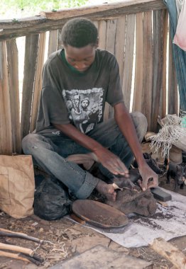 Arusha, Tanzanya - 2014 olabilir. Mto wa, yerdeki yerel Tanzanya erkekler oyma Arusha bölge Mbu Köyü, ahşap
