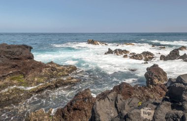Tenerife, Kanarya Adaları güneşli bir günde kayalarda boyunca kırma dalgalar.