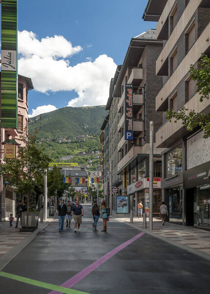 ANDORRA LA VELLA, ANDORRA - SEPTEMBER 2014. Anonymous people walking through the central streets of Andorra on a sunny day. It is a city surrounded by the mountains of the Pyrenees.