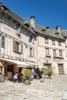 Conques, Aveyron, Fransa - Eylül 2014. Anonim insanlar güneşli bir günde Conques ortaçağ köyü sokaklarında yürüyüş.