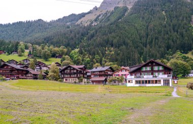 Bulutlu bir günde İsviçre 'deki Murren dağlarında ahşap evler