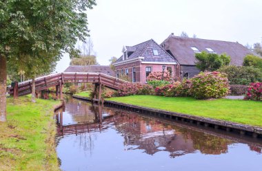 Giethoorn, bulutlu bir günde kanalları ve kırsal evleri olan Hollanda köyü.