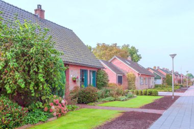 Giethoorn, bulutlu bir günde kanalları ve kırsal evleri olan Hollanda köyü.