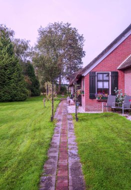 Giethoorn, bulutlu bir günde kanalları ve kırsal evleri olan Hollanda köyü.