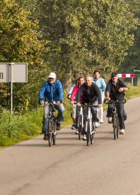 Giethoorn, Overilssel, Holland-Eylül 2014. İnsanlar bir bisiklet üzerinde bir köy sokak bulutlu bir günde sürme.
