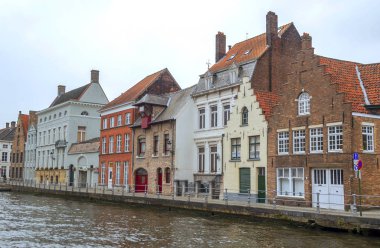 Bulutlu bir günde ortaçağ tarzı cepheleriyle Belçika 'da Bruges sokakları.