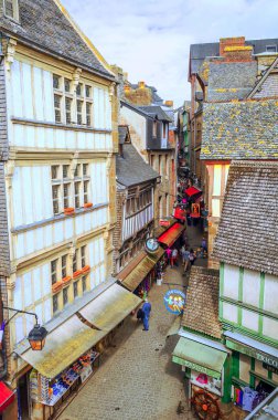 Monte Sant Michael, Normandia, Fransa-Eylül 2014. Anonim turist olarak ortaçağ köyü Sant Michael bulutlu bir günde.