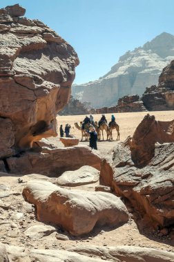 Wadi Rum, Ürdün-Şubat 2015. Turistler Wadi Rum çöl. Wadi Rum, Güney Ürdün'bulunan korumalı bir çöl alandır. Ishrin gibi etkileyici Kumtaşı Dağları ve Bu taş köprü gibi doğal kemerler ile karakterizedir