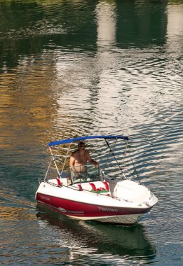 Güneşli bir günde bir tekne içinde Llanes sürüş adam.