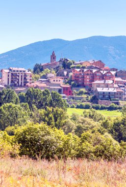 Güneşli bir günde ekili alanlar tarafından çevrili İspanya Kuzey kırsal köy.