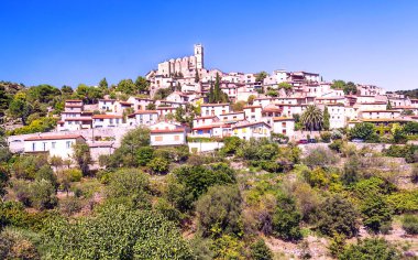Güneşli bir günde Fransız Alpleri'nde bir tepe üstünde yer alan kırsal köy.