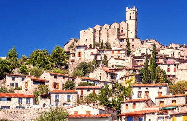 Güneşli bir günde Fransız Alpleri'nde bir tepe üstünde yer alan kırsal köy.