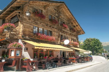 Grimentz, İsviçre-Eylül 2015. Griemntz Saint Luc Vadisi'nde sokaklarında yürürken anonim insanlar. Onun ahşap evler ve bazı dağlar görebilirsiniz. Saint-Luc bölge Sierre, İsviçre Valais kentinde bir köydür.