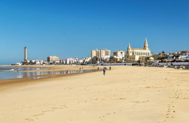 Chipiona, Cadiz, İspanya-Haziran 2016. Cadiz ışıkta kıyıları turistik Belediyesi sahil boyunca güneşli bir günde yürüyen turist.