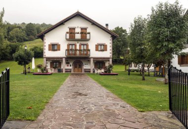 Bulutlu bir günde İspanya Navarra Pyrenees dağlarda alanları ile orman evi.