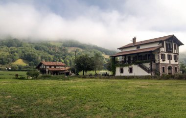 Bulutlu bir günde İspanya Navarra Pyrenees dağlarda alanları ile orman evi.