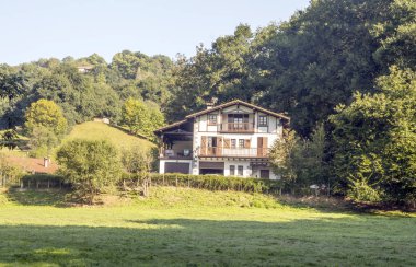 Bulutlu bir günde İspanya Navarra Pyrenees dağlarda alanları ile orman evi.