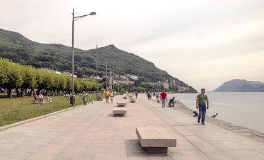 Castro Urdiales, İspanya-Septemeber 2019. İnsanlar ve turistik sahil alanının büyük bir tarafta bina ile yürüyüş.