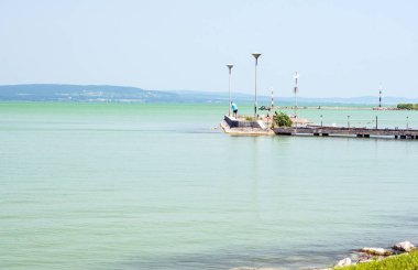 Balatonlelle, Macaristan-Haziran 2019. Güneşli bir günde şehrin gölü yakınında bir yaz günü çim turist.