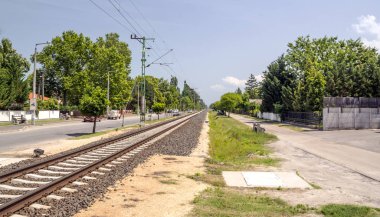 Balatonlelle, Macaristan-Haziran 2019. Güneşli bir günde doğa ile çevrili kasabanın gölü yakınında bir yaz günü sokakta Tren istasyonu.