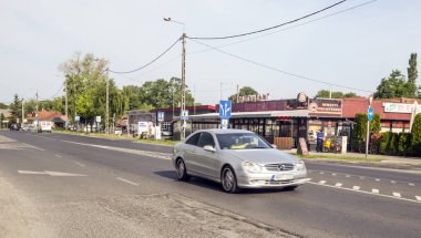 Balatonlelle, Macaristan-Haziran 2019. Güneşli bir günde köyde evleri ile çayırlarda Macar kasabasının Yolu.